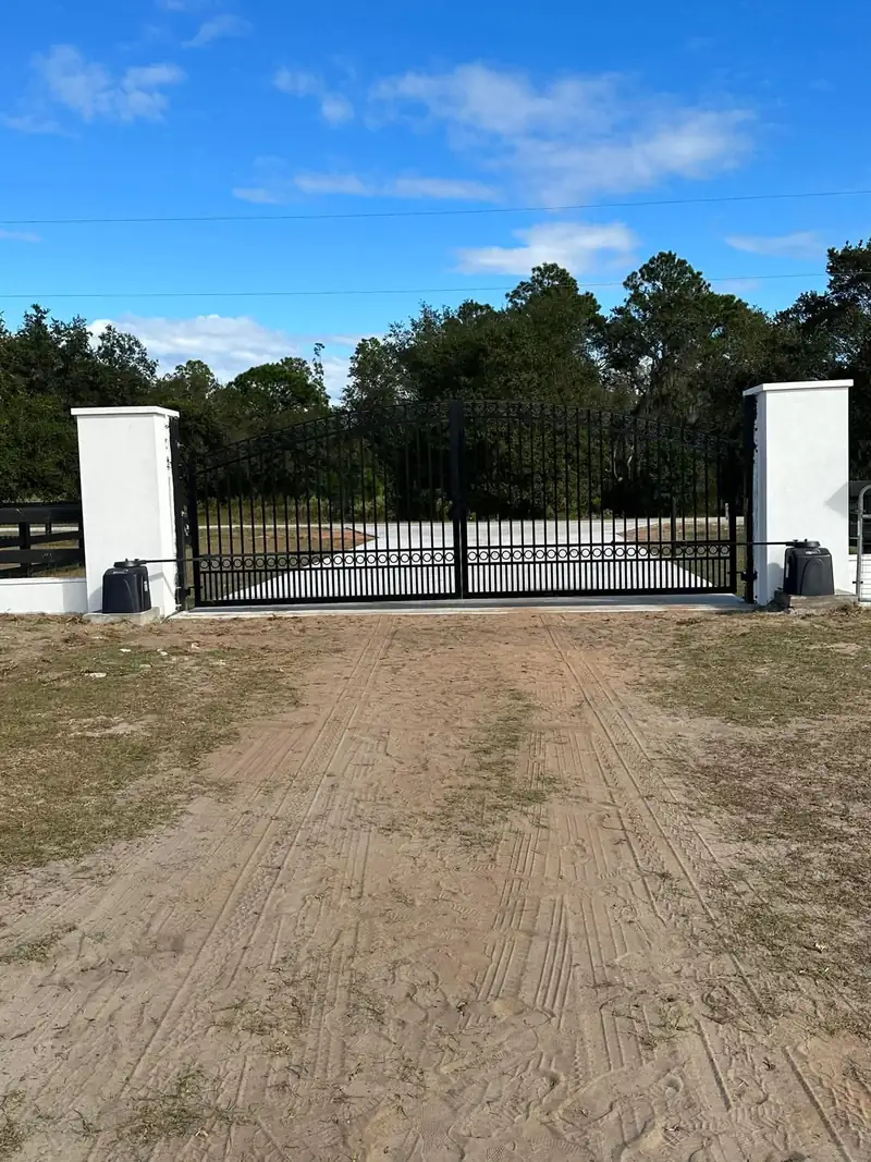 White stucco columns framing an arched double gate